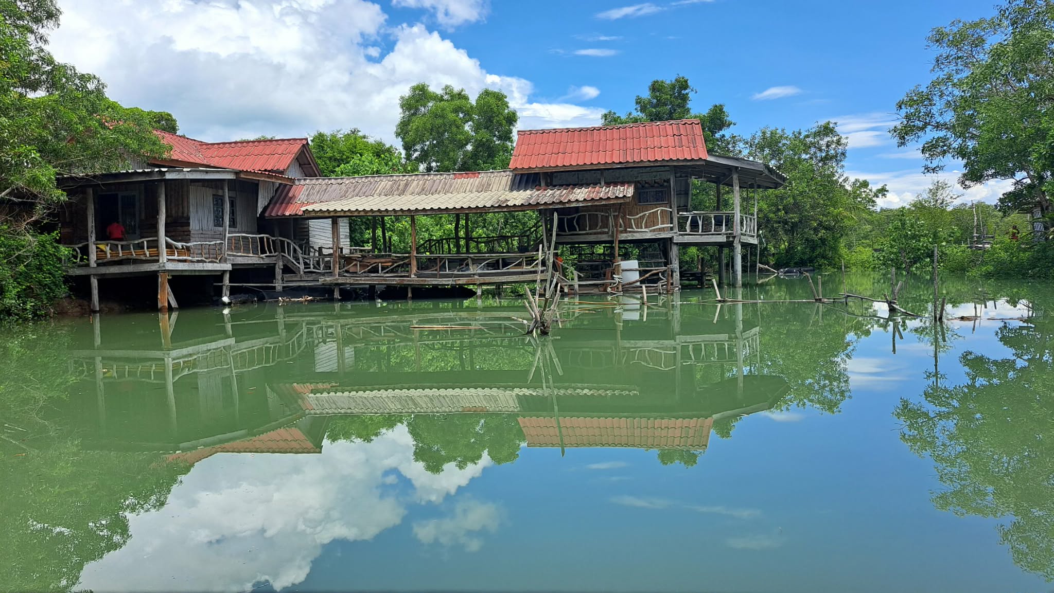 BigHugHome's stilt cabins reflected in the mangrove canal